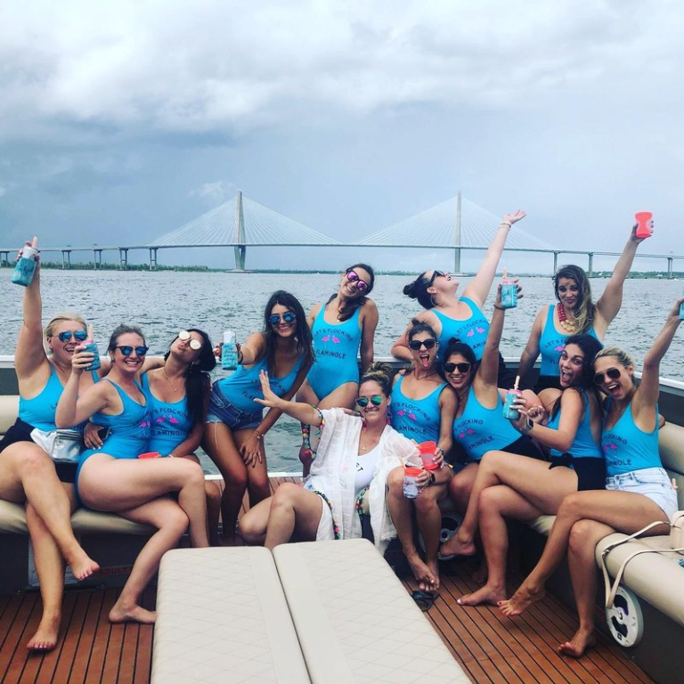 A group of women wearing blue on a boat partying
